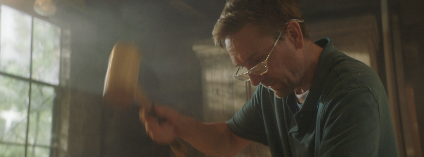 Ben works with a mallet and chisel to build timber frames
